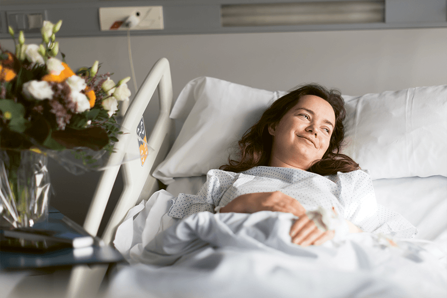 Junge Frau liegt krank im Krankenhausbett