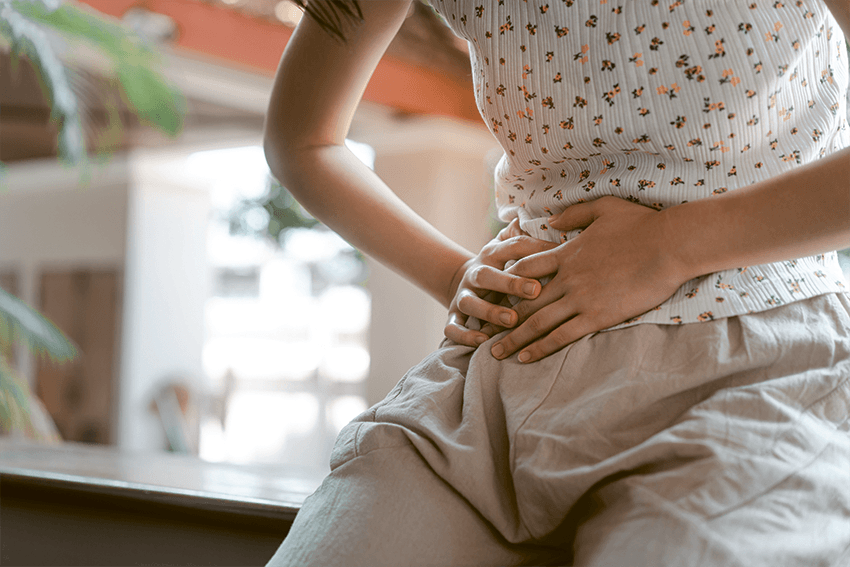Nahaufnahme einer Frau mit Händen auf Ihrem Bauch