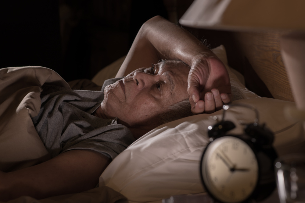 Seniorin liegt nachts im Bett wach